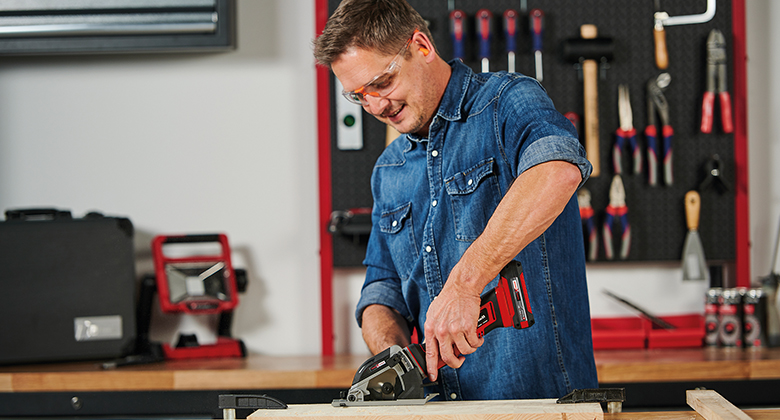 man using a cordless mini circular saw